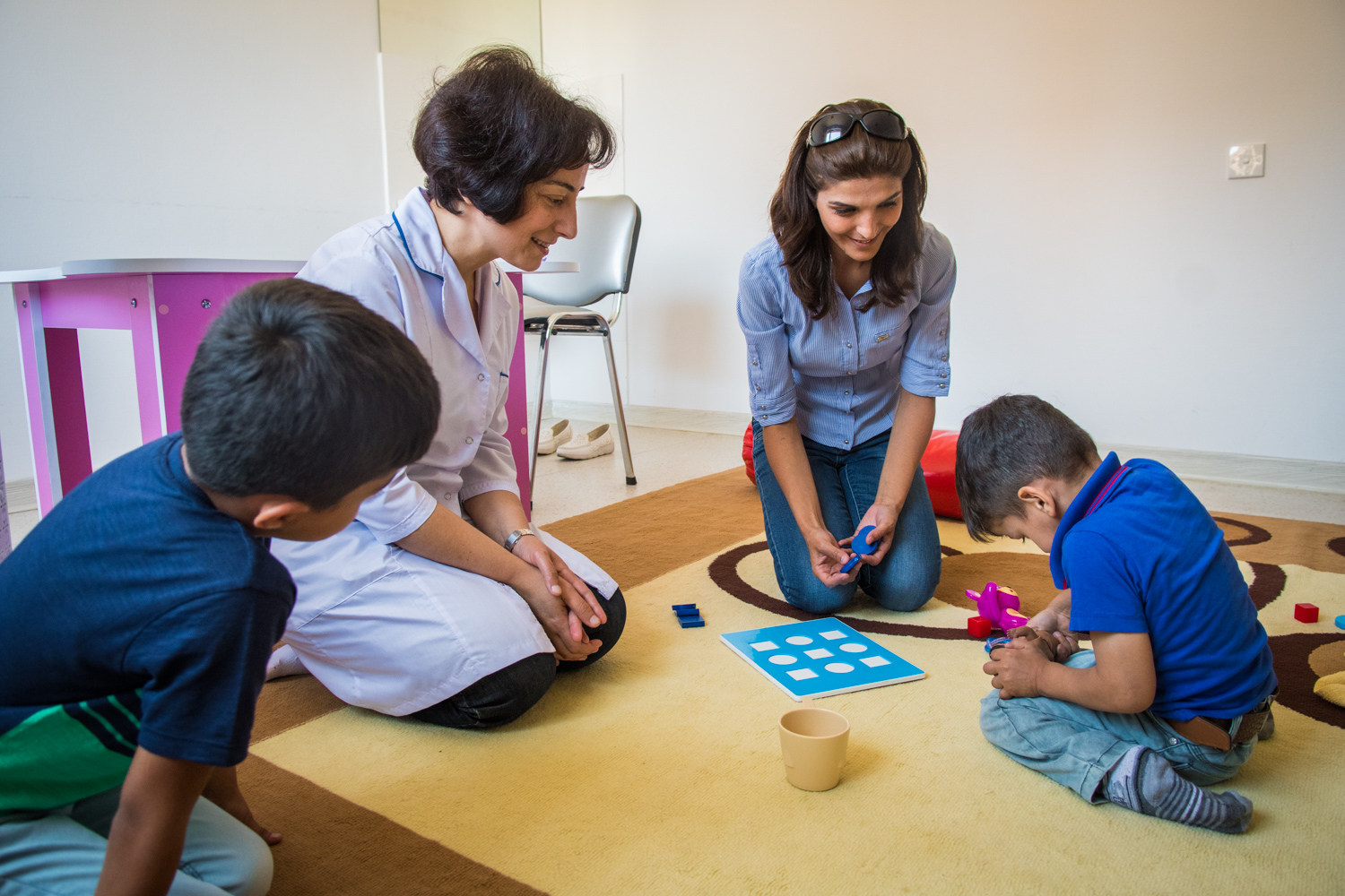 Baku Rehabilitation Centre. A disabled child with his brother are participating in the activities the caregiver is encouraging them to follow. Azerbaijan has a population of 8MM, of which 2.8MM are children under 18.