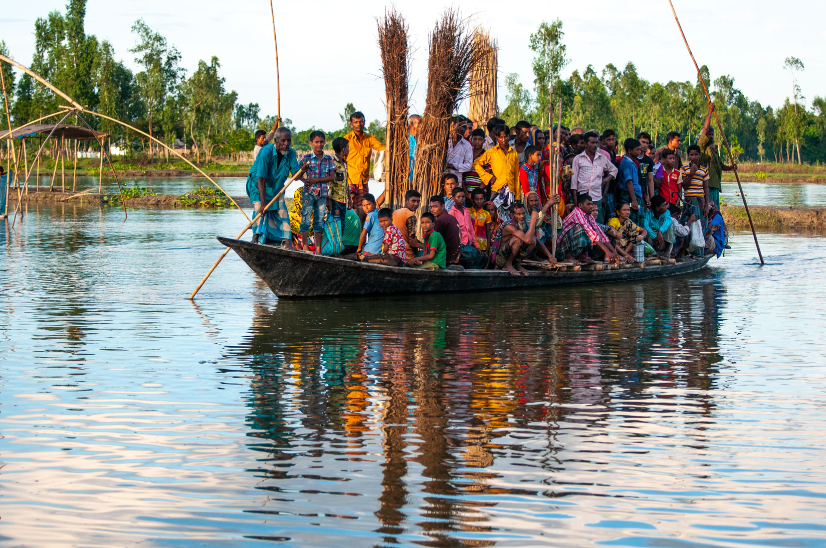 A boat at its full capacity is transporting people from the islands, or isolated places in the inland that has better access if reached by boat. They are reaching the aid distribution centers to bring some food to their families.