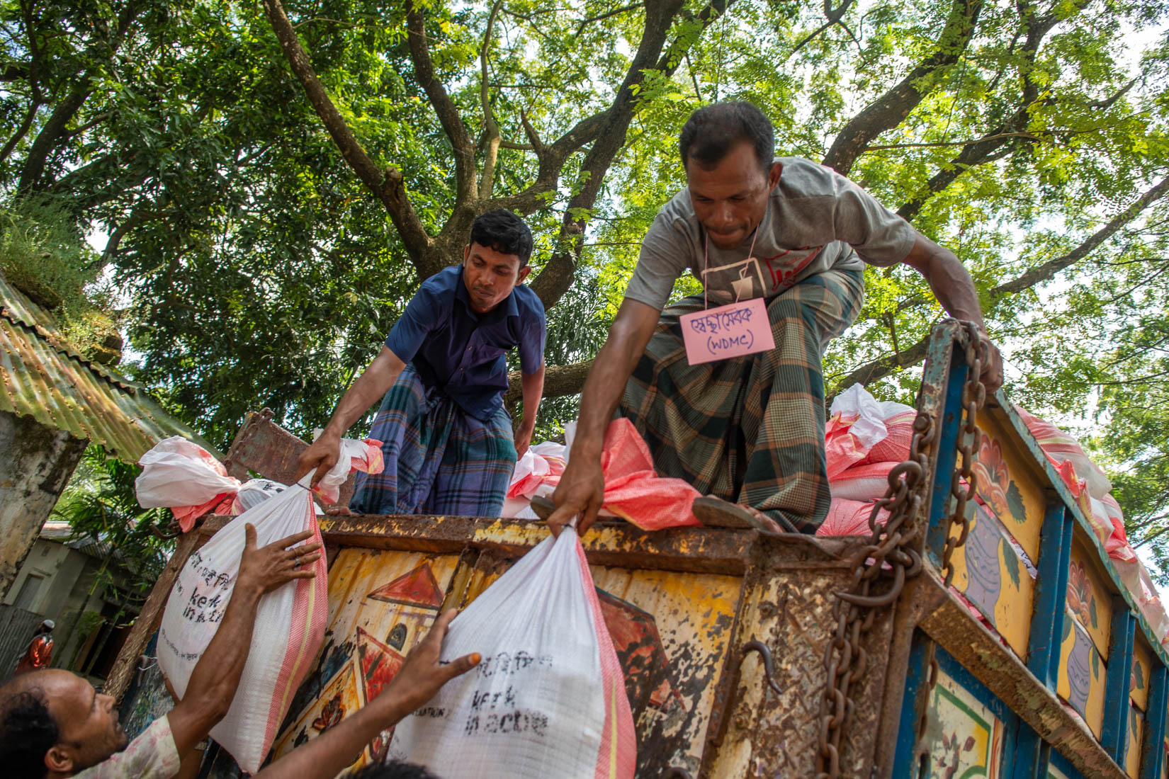 Relief materials is being downloaded from a truck at Pachpir Primary school ground.