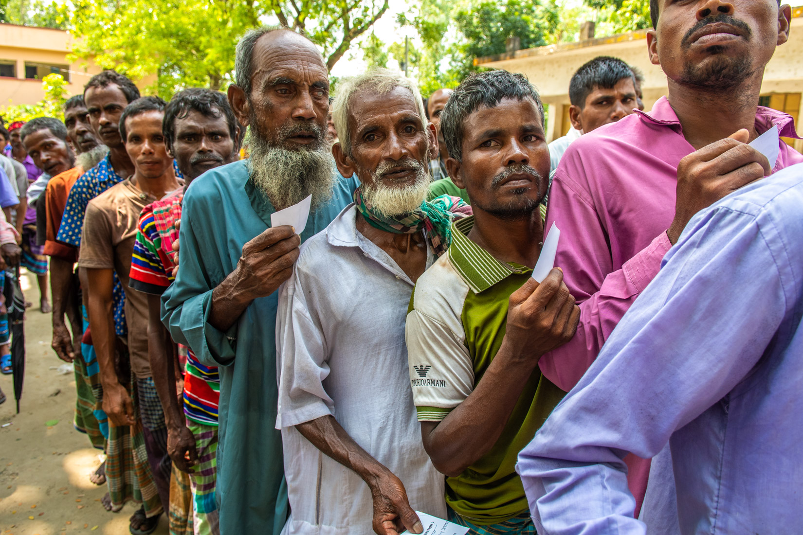 Woman after receiving the food heading back to where her family is settled, with a strong look as of fully determine to move on in life.